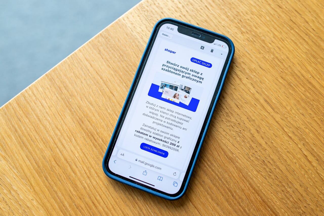 services-01 Smartphone displaying e-commerce advertisement on wooden surface, ideal for digital marketing themes.